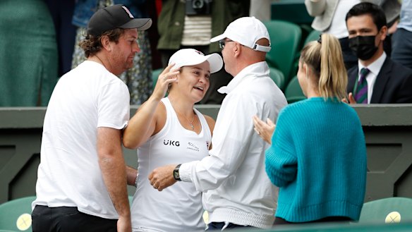 Team effort: Barty emulated Pat Cash in 1987 by climbing up to embrace her support crew