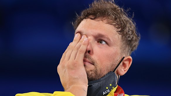 Dylan Alcott wipes away a tear on the podium in Tokyo.