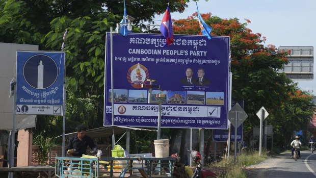 A vendor sells dried freshwater clam near political party posters for the barred Candlelight Party, left, and the CPP.