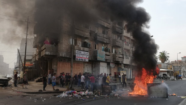 Anti-government protesters set a fire and block roads in Baghdad, Iraq.