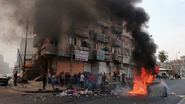 Anti-government protesters set a fire and block roads in Baghdad, Iraq.