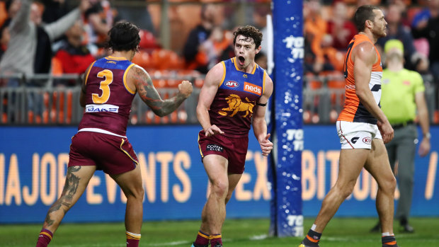 Roar power: Lachie Neale (centre) notches another goal for the Lions during their round 16 win over GWS at Giants Stadium.