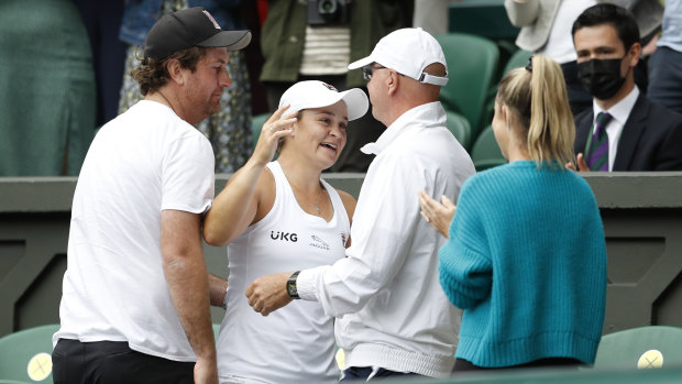 Team effort: Barty emulated Pat Cash in 1987 by climbing up to embrace her support crew