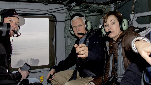 Vice-President Mike Pence and Iowa Governor Kim Reynolds, second right, point to flooded areas, with Nebraska Governor Pete Ricketts, left, during a helicopter flight over areas affected by the flooding of the Missouri and Elkhorn Rivers on Tuesday. 