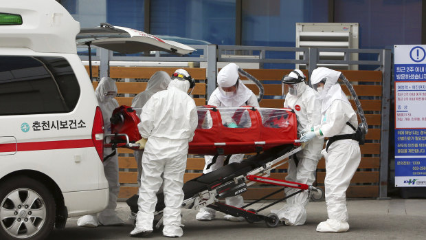 Medical workers transfer a coronavirus patient to a hospital in Chuncheon, South Korea.