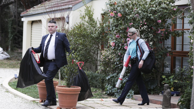 AFP officers depart after the raid on the home in Canberra.