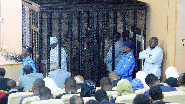 Omar al-Bashir, pictured in white in the cage, returned to court on August 19 to answer corruption charges.