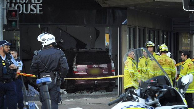 Police and emergency workers stand in front of Hijab House in Greenacre after a car drove into the shop, injuring 14 people.