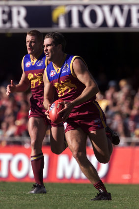 Marcus Ashcroft runs the ball out of the Lions’ defence, with Michael Voss in support, in 2002.