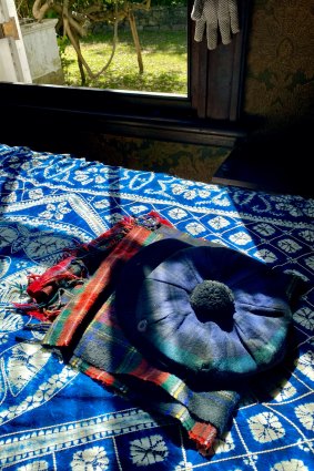 The artist's signature tartan scarf and tam-o-shanter rest on a bed.