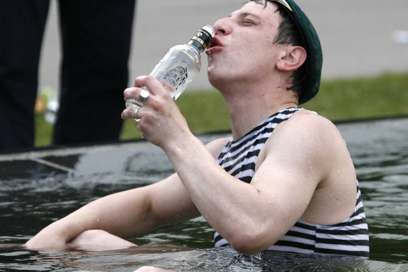 A former border guard drinks vodka to celebrate Border Guards Day as he swims in the main fountain of Moscow’s Gorky Park in 2008.