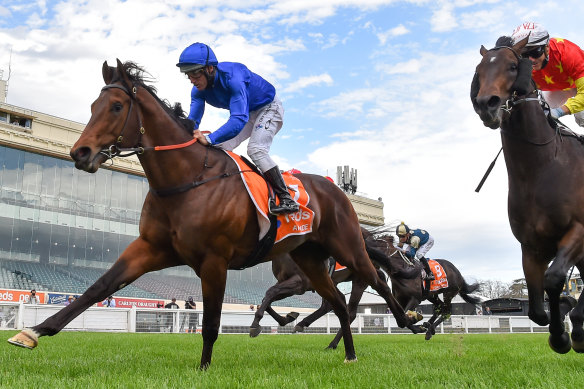 Damien Oliver (blue silks) aboard Anamoe charges to victory in the Caulfield Guineas.