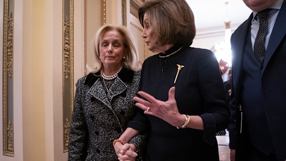 Speaker of the House Nancy Pelosi holds hands with Representative Debbie Dingell, whose deceased husband Trump suggested was in hell. 
