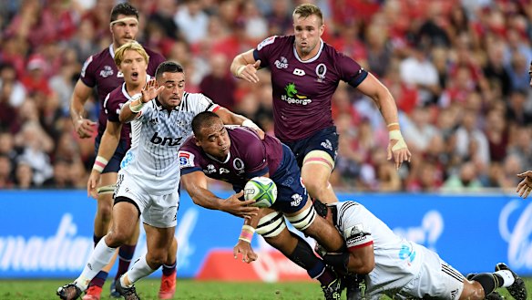 Caleb Timu of the Reds offloads in a tackle during the round 3 Super Rugby match against the Crusaders at Suncorp Stadium on Saturday.