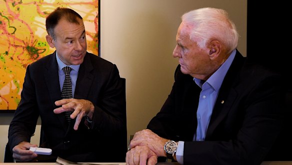 Atomo Diagnostics co-founder John Kelly (left) shows investor Lang Walker the self-testing HIV blood kit, which might also be used for testing COVID-19. 