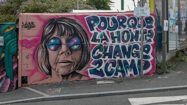 This photograph shows a mural created by Maca_dessine depicting Gisele Pelicot and a sentence reading “So that shame changes sides” in Gentilly, south of Paris.