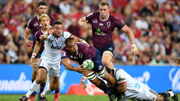 Caleb Timu of the Reds offloads in a tackle during the round 3 Super Rugby match against the Crusaders at Suncorp Stadium on Saturday.