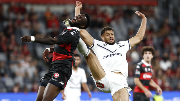 Victory substitute Rudy Gestede collects  Wanderers striker Bernie Ibini high. The resulting penalty gave the Wanderers the lead.