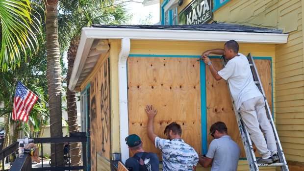 Employees of the Island Root Kava Lounge board up the windows of the business in preparation for Hurricane Dorian in Melbourne, Florida.