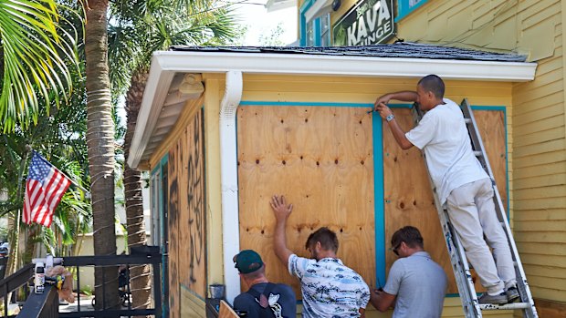 Employees of the Island Root Kava Lounge board up the windows of the business in preparation for Hurricane Dorian in Melbourne, Florida.