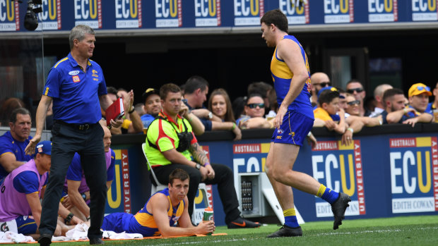 West Coast defender Jeremy McGovern leaves the field for treatment.