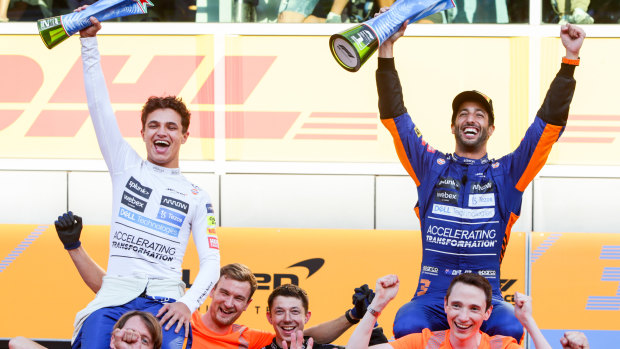 Lando Norris and Daniel Ricciardo celebrate with the McLaren crew.
