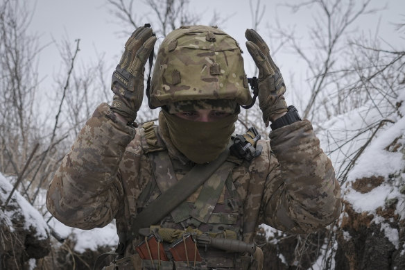 Ukraynalı bir asker, Ocak 2022'de, Rus işgalinden günler önce, Ukrayna'nın doğusundaki Luhansk bölgesinde cephe hattı konumunda kaskını düzeltiyor.