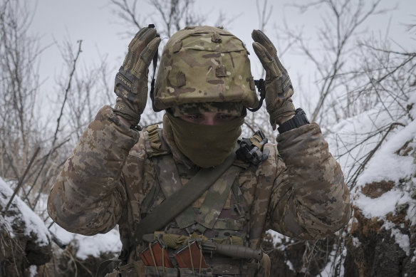 A Ukrainian serviceman adjusts his helmet while working to fix a trench that was damaged by a mortar strike at a front line position, less than 100 metres from Russian separatists in the Luhansk area, eastern Ukraine, in January.