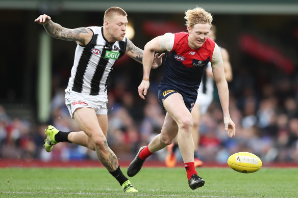 Clayton Oliver is chased by Collingwood’s Jordan De Goey.