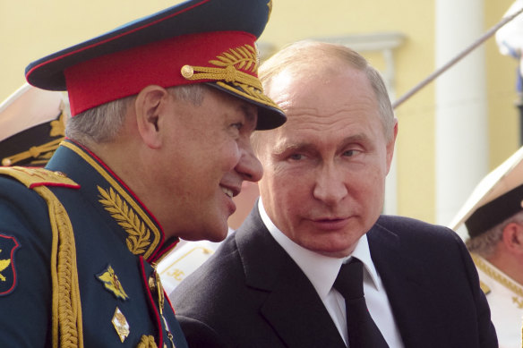 Russian Defence Minister Sergei Shoigu speaks to President Vladimir Putin during celebrations in St Petersburg in July.