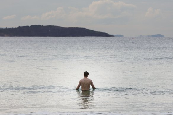 A man braves the cold air to go for a swim at Manly Beach, Sydney, 30 June 2022. 