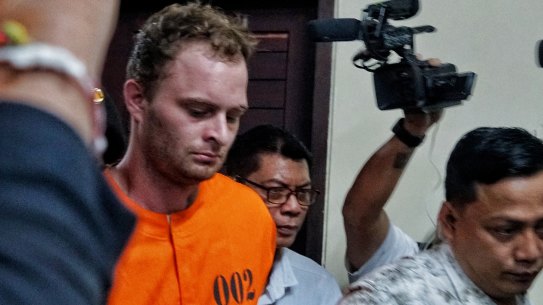 Wearing an orange detainee outfit, Drew Donal Ireland is led into a press conference in Bali on Tuesday.