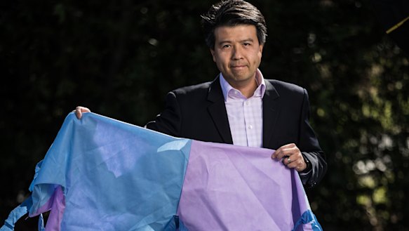 Geelong GP Bernard Shiu holds up a gown made from recycled medical material.