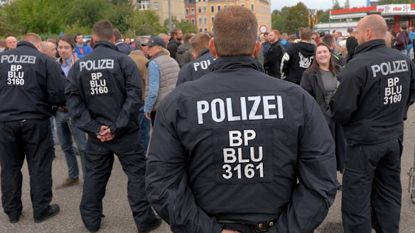 Police officers observe right-wing demonstrators during a far-right demonstration in Chemnitz, Germany.
