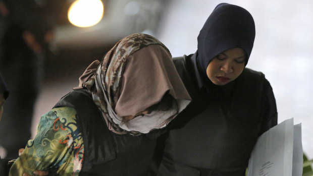 Vietnamese Doan Thi Huong, left, is escorted by police as she arrives for a court hearing on Thursday.