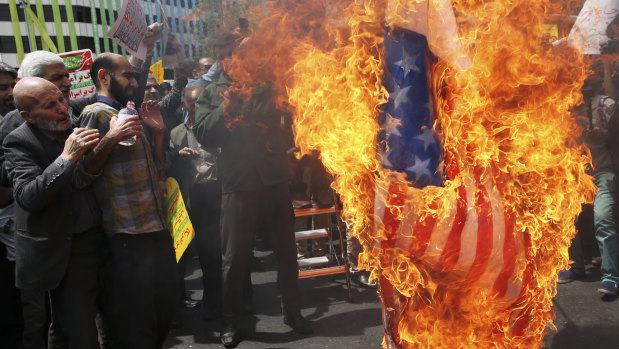 Iranian protesters burn a representation of the US flag in Tehran after Trump announced the US was pulling out of the Iran nuclear accord last week.