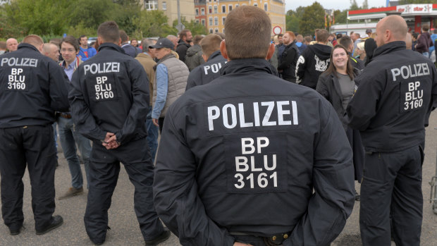 Police officers observe right-wing demonstrators during a far-right demonstration in Chemnitz, Germany.