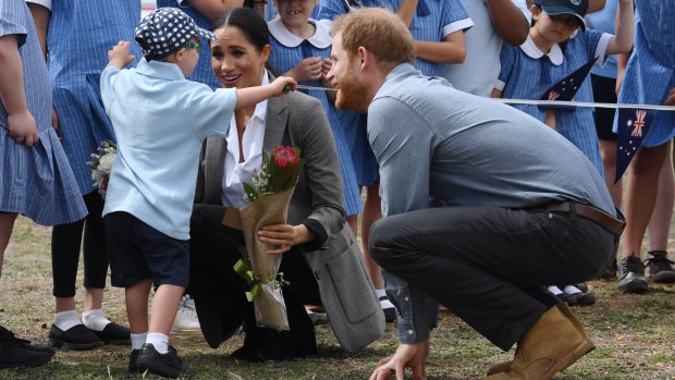 Britain's Prince Harry, the Duke of Sussex looks on as his wife Meghan, the Duchess of Sussex is hugged by student Luke Vincent of Buninyong Public School.