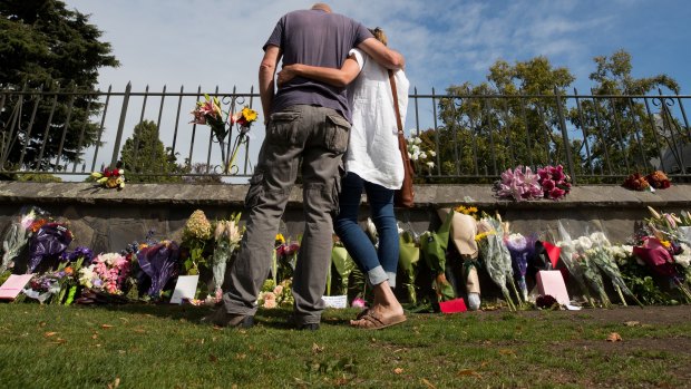 People pay their respects at a floral tribute at the Christchurch Botanical Gardens.