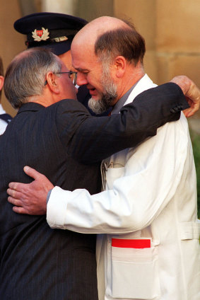 PM John Howard comforts the chief surgeon Dr Bryan Walpole after the State Service for the Port Arthur Victims at The Cathedral Church of Saint David, Hobart on May 1, 1996.