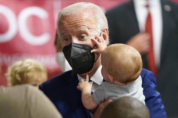 US President Joe Biden holds a baby at a COVID-19 vaccination clinic in Washington in June.