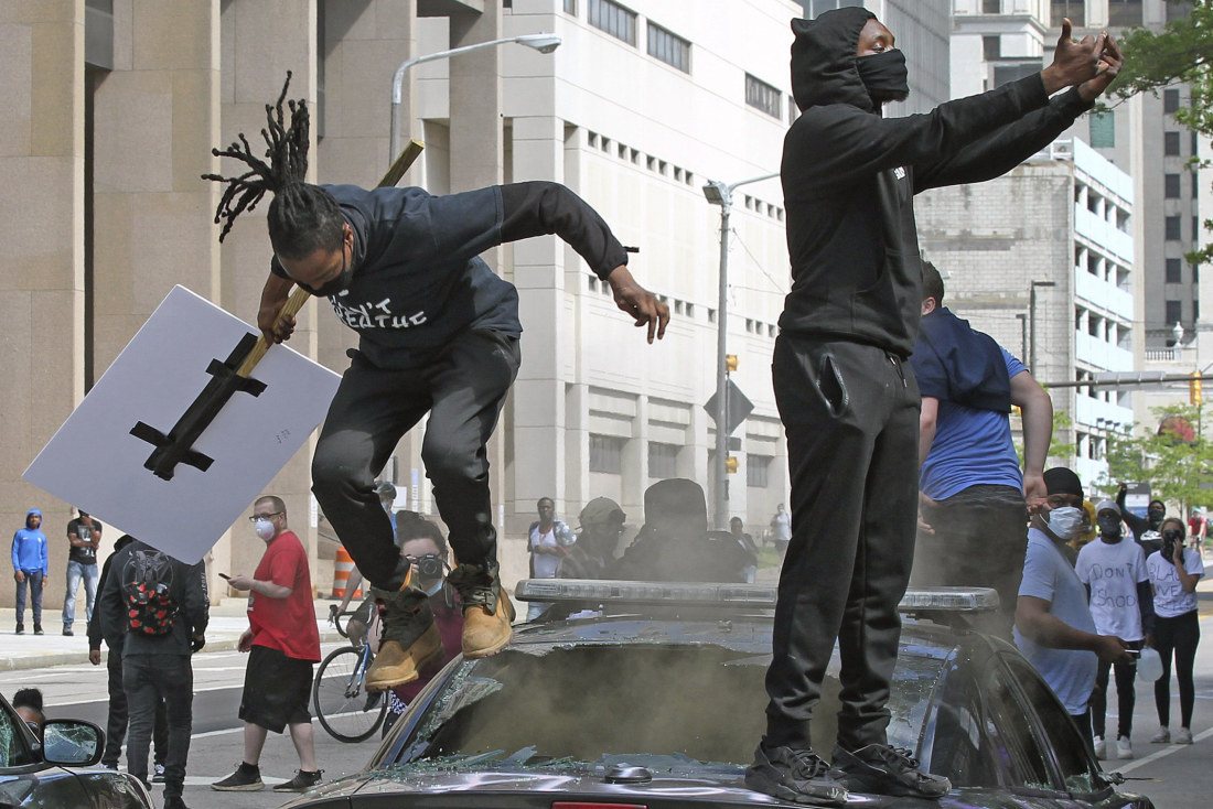 Protesters stomp on a Cleveland police cruiser during a day of nationwide protests seeking justice in the death of George Floyd.