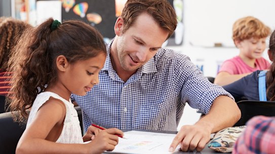 A teacher helping a student in class.