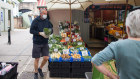 A stall holder serves a customer on a fruit and vegetable stall at the market in Norwich, UK. The country is on course for deep recession.