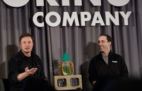 Elon Musk, co-founder and chief executive officer of Tesla (left), speaks as Steve Davis the operations head of Boring Company, (right), listens during a Boring event.