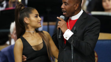 Bishop Charles Ellis, right, holds Ariana Grande after her performance.