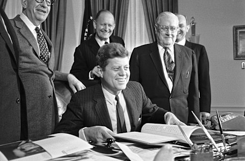 Engaging with the world: President John F. Kennedy at his White House desk in 1961 after signing the instrument making the US a member of the Organisation for Economic Co-operation and Development.