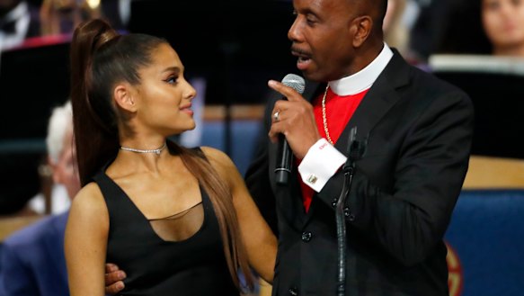 Bishop Charles Ellis, right, holds Ariana Grande after her performance.