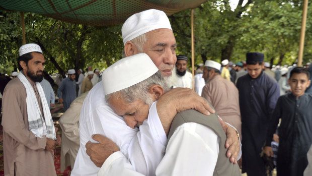 Pakistani Muslims greet each other after offering Eid al-Fitr prayers in Peshawar.