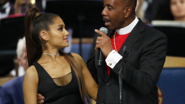 Bishop Charles Ellis, right, holds Ariana Grande after her performance.